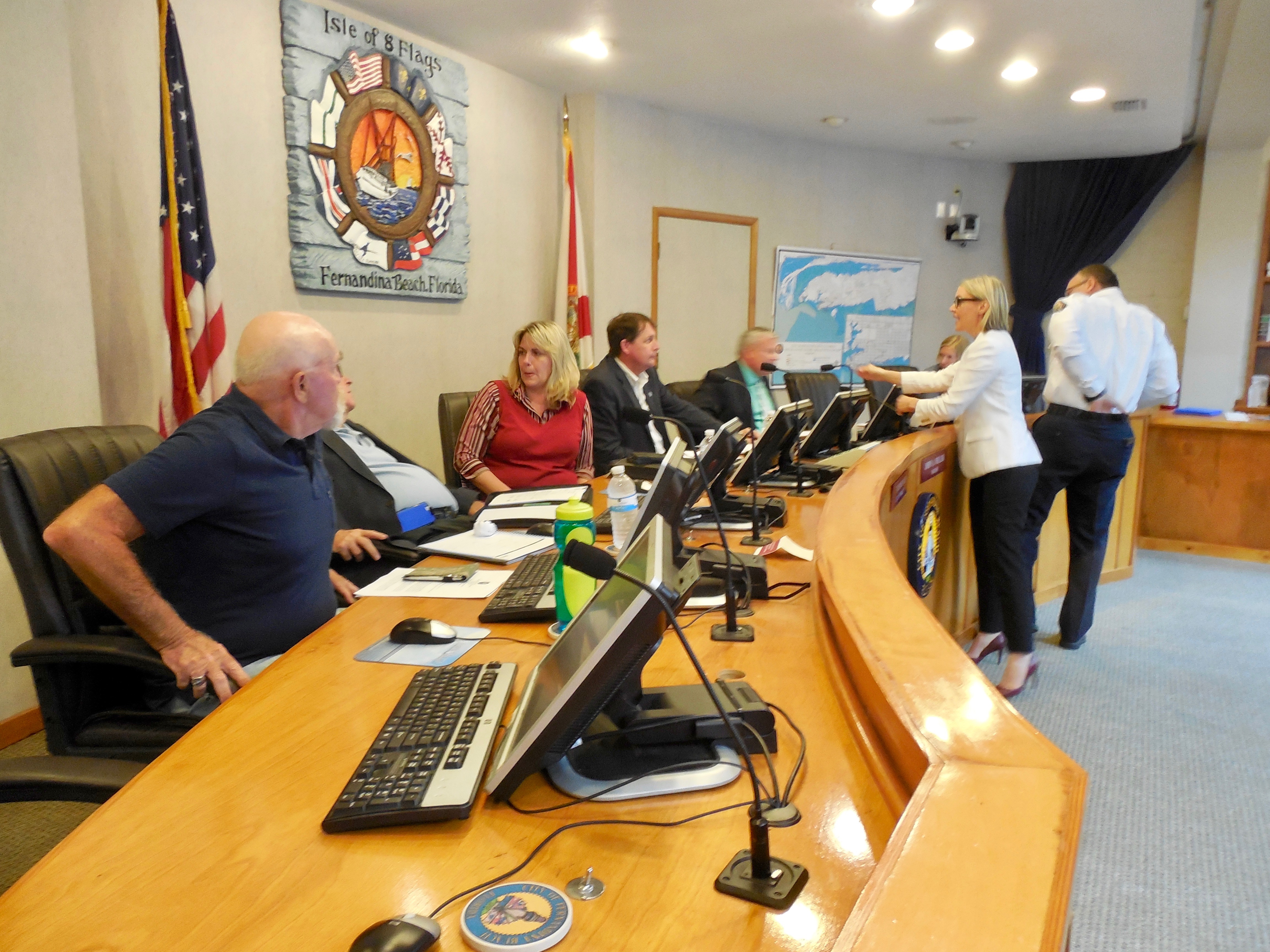 Fernandina Beach City Clerk Caroline Best and Fire Chief Ty Silcox chat with city commissioners before meeting begins.